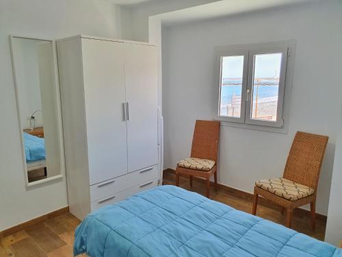 Pozo Izquierdoにあるpozoのベッドルーム1室(青いベッド1台、椅子2脚付)