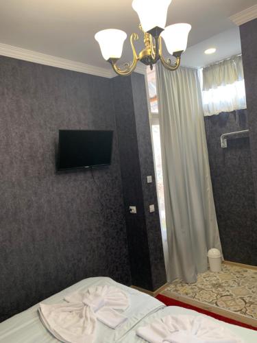 a bedroom with a bed and a television on a wall at Your House In Tbilisi in Tbilisi City