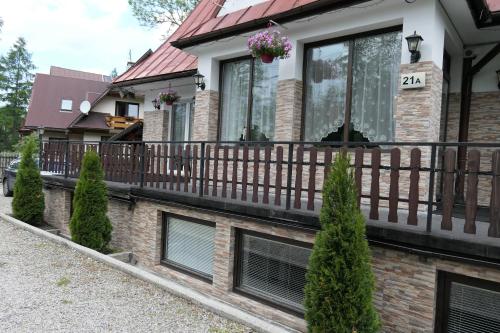 a house with a wooden fence on a balcony at Apartamenty u Łukasza in Zakopane