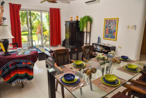 a dining room and living room with a table and chairs at Villa Playa Vintage in Playa del Carmen