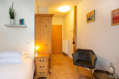 a bedroom with a bed and a chair in it at Landhotel Teichwiesenhof in Oldenburg in Holstein