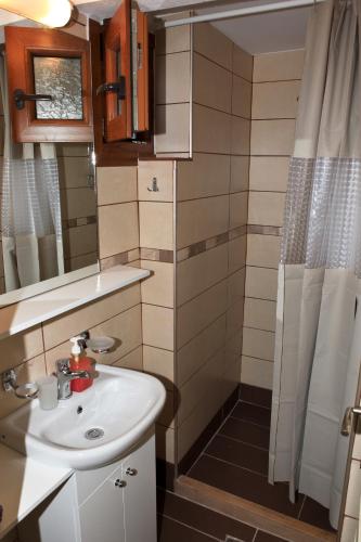 a small bathroom with a sink and a shower at Panormos Maisonettes in Panormos Skopelos