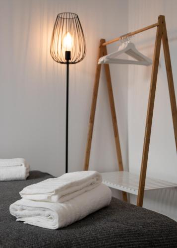 a room with a bed with a lamp and white towels at Lavadeira's House in Olhão