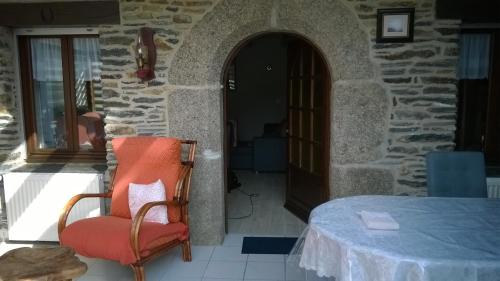 une chambre avec une table et une chaise à côté d'un bâtiment dans l'établissement Chez Suzette & John, à Saint-Mayeux