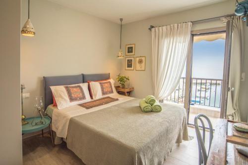 a bedroom with a bed and a balcony at Eftopia Beachfront 2-bedrooms apartment in Kokkari
