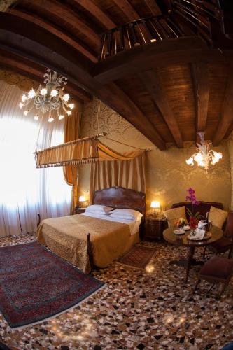 a bedroom with a bed and a chandelier at Hotel Palazzo Abadessa in Venice