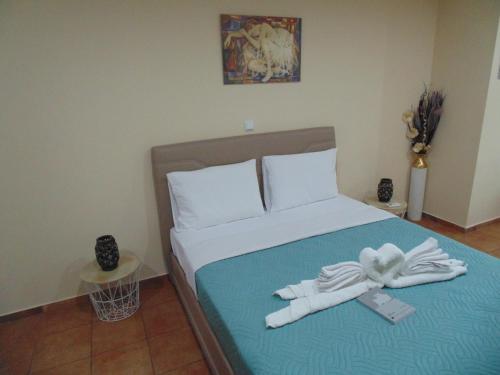 a bedroom with a bed with two towels on it at Elisian Studios in Néa Karváli