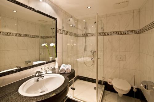 a bathroom with a sink and a shower and a toilet at Germanenhof in Sandebeck
