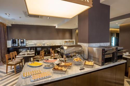 a breakfast buffet in a restaurant with food on a counter at Fuente Mayor Hotel Centro in Mendoza