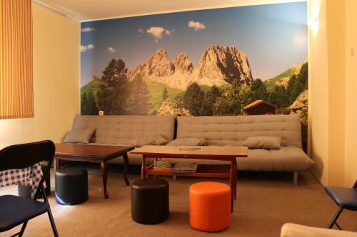a living room with a couch and a mountain mural at Hostel Trajan in Donji Milanovac