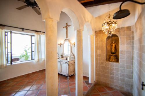 La salle de bains est pourvue d'un lavabo et d'une croix sur le mur. dans l'établissement BellView Hotel Boutique, à Puerto Vallarta