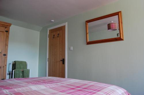 a bedroom with a bed and a mirror on the wall at Glenelg in Tobermory