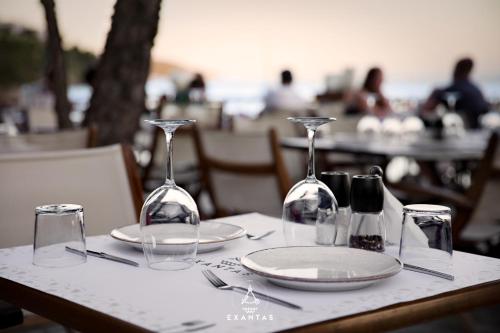 a table with two wine glasses and plates on it at Megali Ammos House in Megali Ammos