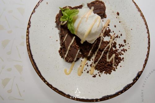 a piece of cake with whipped cream and a mint on a plate at Megali Ammos House in Megali Ammos