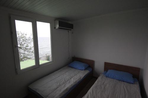 dwa łóżka w małym pokoju z oknem w obiekcie Hitas house w mieście Czakwi