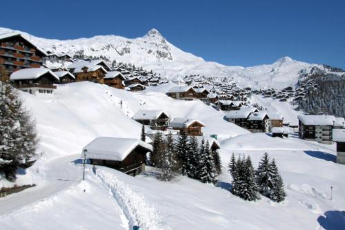 a resort in the snow with a mountain at Familienhotel Garni Sporting in Bettmeralp