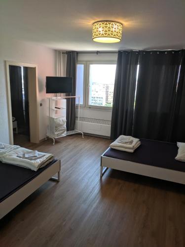 a living room with two beds and a window at FeWo Köln in Cologne