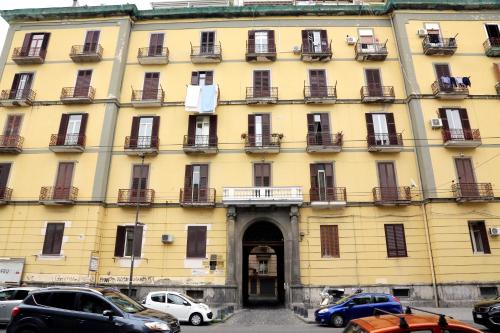 a large yellow building with cars parked in front of it at Live Naples in Naples
