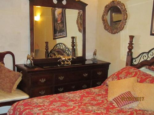 a bedroom with a dresser and a bed and a mirror at FLEUR DE LAC EUROPERAN INn in Lake Arrowhead