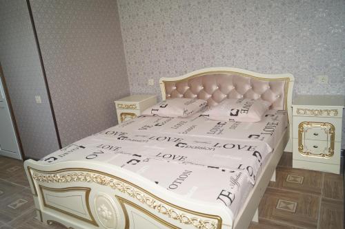 a bedroom with a white bed with a gold frame at Валентина in Gagra