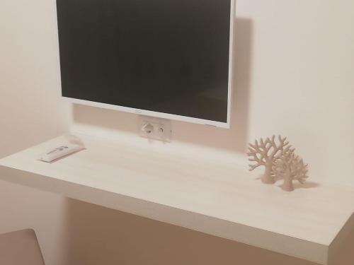 TV de pantalla plana en un estante blanco en Casa Felice, en Savelletri di Fasano