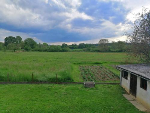 a farm field with a building and a field of crops at Apartman Kopriva in Koprivnica
