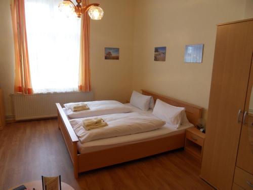 a bedroom with a bed with white sheets and a window at Ferienappartements Rindfleisch in Stralsund