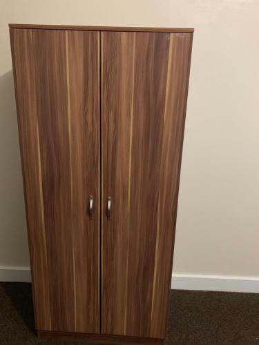 a wooden cabinet with two doors in a room at Hagley Hotel in Birmingham