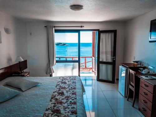 a bedroom with a bed and a view of the ocean at La Boheme Hotel e Apart Hotel in Búzios