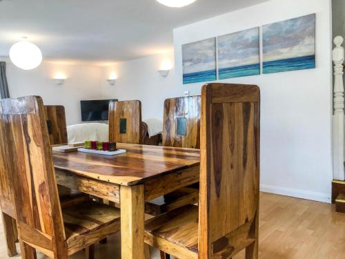 a dining room table with chairs and a wooden table at THE OLD RECTORY ROSE COTTAGE in Jacobstow 10 mins to Widemouth bay and Crackington Haven,Nearby Bude,Tintagel,Port Issac,Clovelly,PARKING FOR LARGE AND MULTIPLE VEHICLES in Jacobstow
