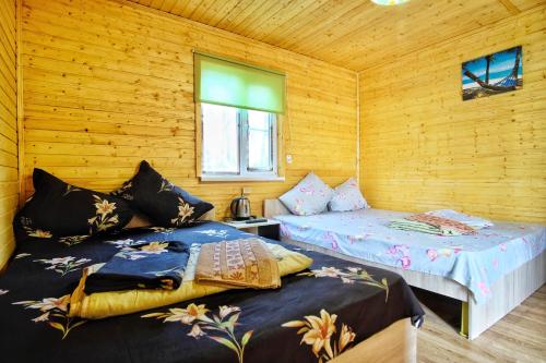 Duas camas num quarto com paredes de madeira em Motel MaksiM-4 DON em Pavlovsk