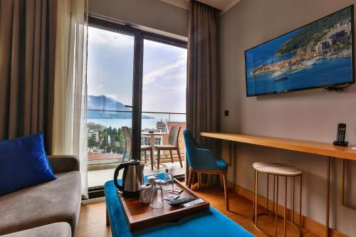 a living room filled with furniture and a tv at Hotel Lusso Mare by Aycon in Budva
