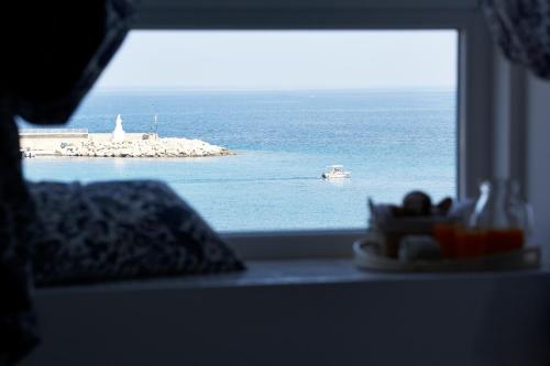 una finestra con vista sull'oceano e su una barca di Palazzo Dogana Resort ad Agropoli