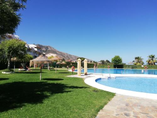 a resort with a swimming pool with a mountain in the background at Benalmarina Sea View Apartments in Benalmádena