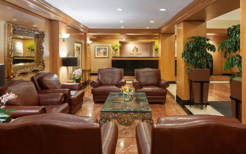 a lobby with leather chairs and a table and a piano at The Manhattan Club in New York