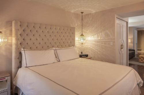 a bedroom with a large bed with white sheets and pillows at The Manhattan Club in New York
