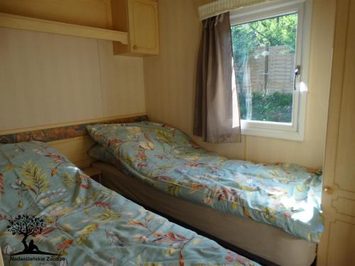 2 camas en una habitación pequeña con ventana en Nadwiślańskie Zacisze en Kozielec