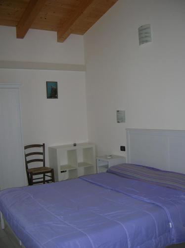 a bedroom with a blue bed and a desk at B&B S'Ena in Suni