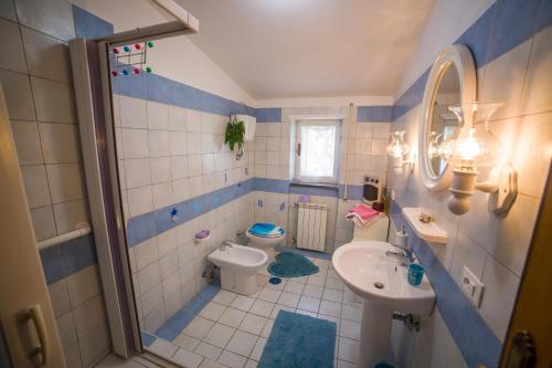 ein blau-weißes Badezimmer mit Waschbecken und Toilette in der Unterkunft Poggio della Roverella Country House in Morlupo