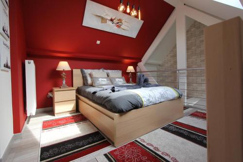 1 dormitorio con cama y pared roja en Orchidee Premium, en Comines