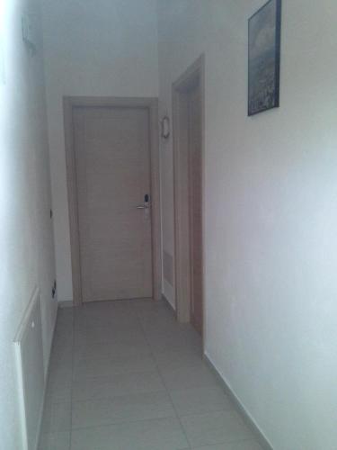 an empty room with a door and a hallway at B&B S'Ena in Suni