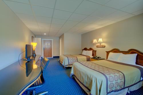 a hotel room with two beds and a flat screen tv at Village Inn Annapolis MD in Annapolis