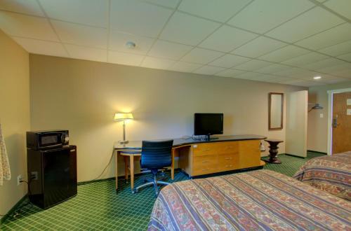 a hotel room with two beds and a desk with a computer at Village Inn Annapolis MD in Annapolis