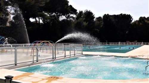 a swimming pool with a water fountain at Domaine de La Coudouliere, Vue Mer, Plage, Piscine et Parc in Six-Fours-les-Plages