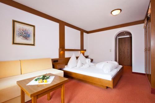 ナウダースにあるAlpengasthof Norbertshöhe Superiorのベッド2台とテーブルが備わるホテルルームです。