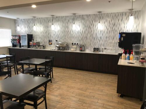 a restaurant with tables and chairs and a counter with a counter at Baymont by Wyndham Moses Lake in Moses Lake