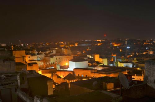 a view of a city at night at Moroccan Dream Hostel in Fès