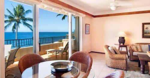 a living room with a view of the ocean at Whalers Cove in Poipu in Koloa
