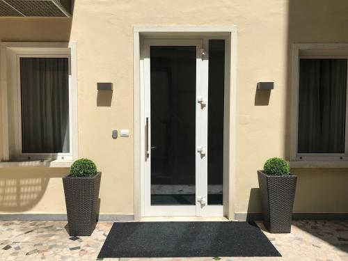 a front door of a house with two potted plants at Italianflat - Design rooms Verona in Verona