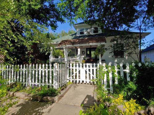 a white picket fence in front of a white house at Delano Bed and Breakfast in Wichita